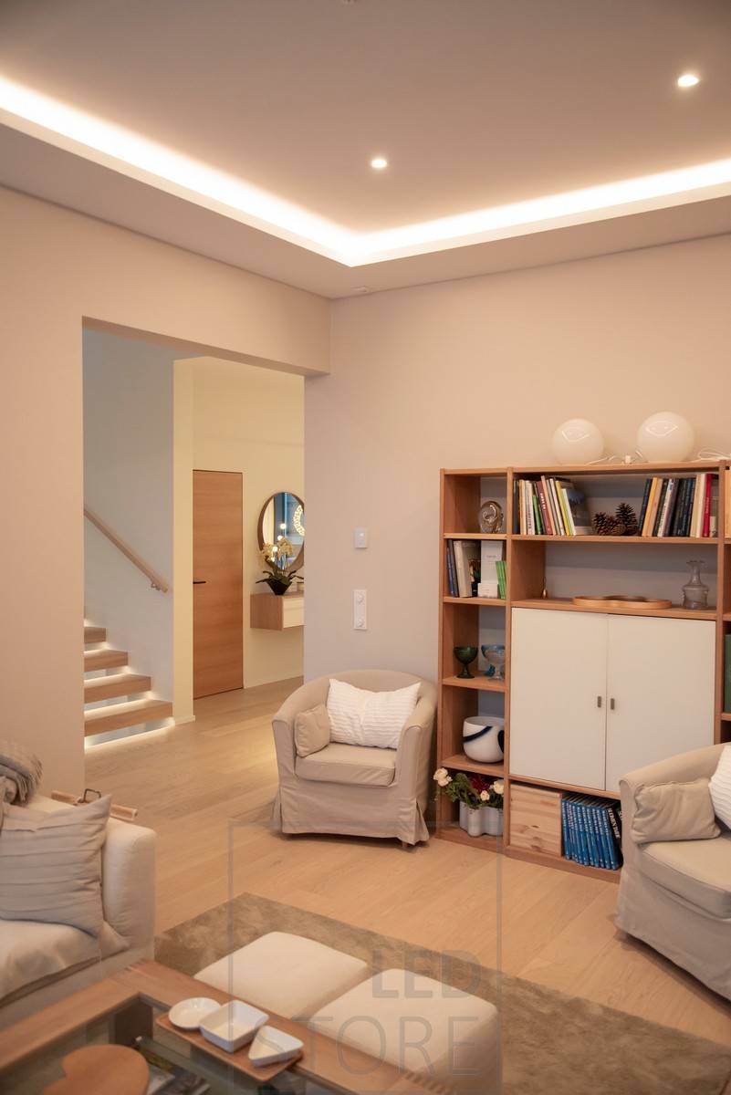 En el salón, focos redondos como downlights y una tira de LED como luz indirecta en el clip del downlight. Ledstore.fi